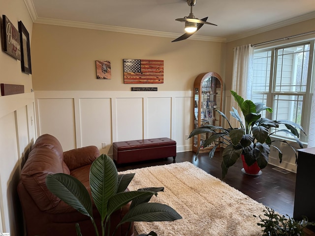 living room with visible vents, wainscoting, ceiling fan, dark wood-style flooring, and crown molding