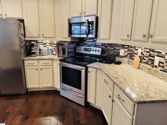 kitchen with tasteful backsplash, a toaster, dark wood-type flooring, light stone countertops, and stainless steel appliances