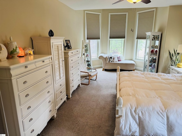 bedroom featuring a ceiling fan, dark colored carpet, multiple windows, and baseboards