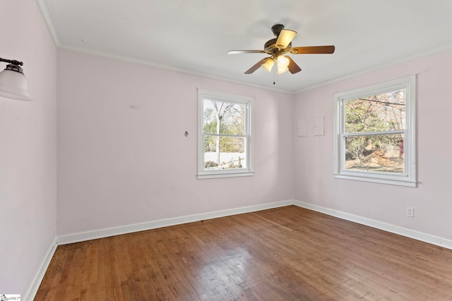 empty room with ornamental molding, ceiling fan, baseboards, and wood finished floors