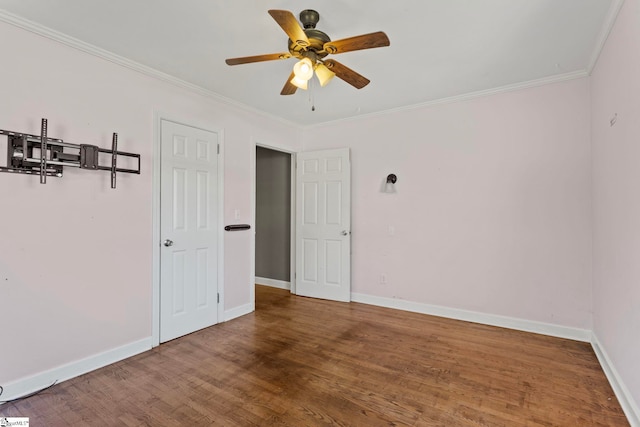 unfurnished room with a ceiling fan, crown molding, baseboards, and wood finished floors