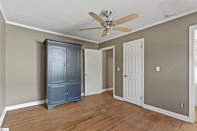 unfurnished bedroom featuring baseboards, ceiling fan, light wood-style flooring, and crown molding