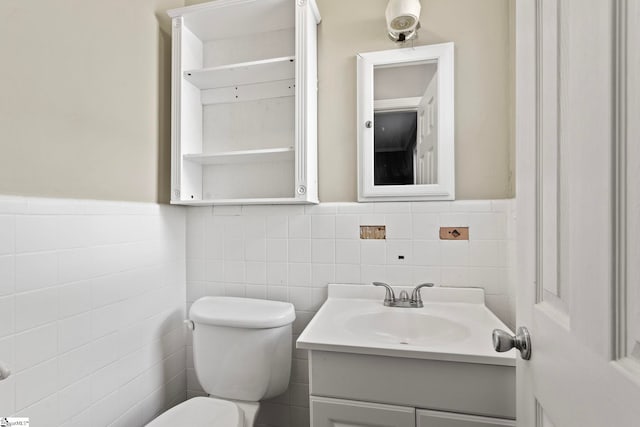 bathroom with toilet, wainscoting, and vanity