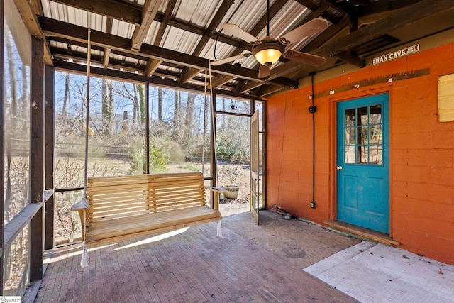 unfurnished sunroom with a ceiling fan