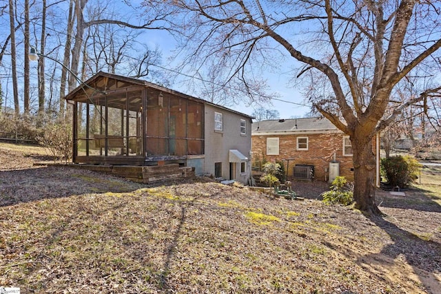 exterior space with a sunroom and brick siding