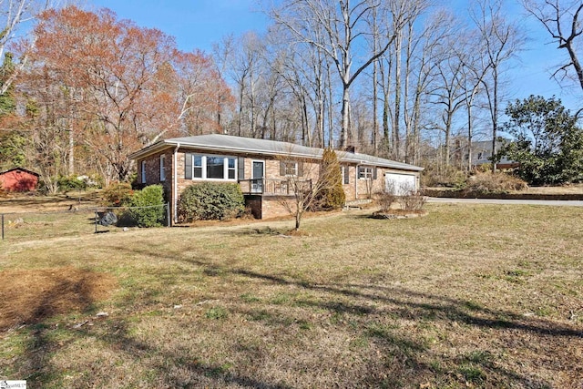 view of front of house featuring a garage, a front lawn, and brick siding