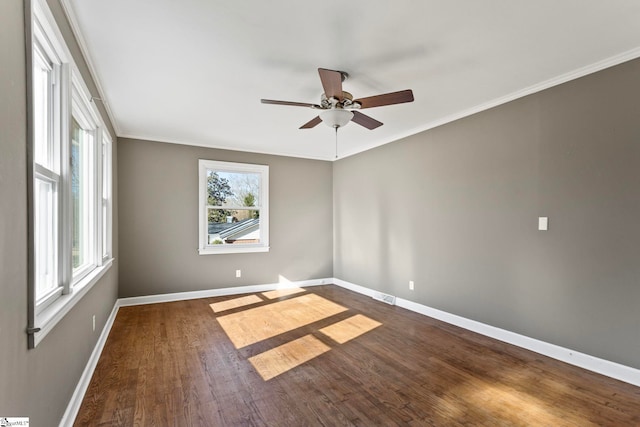 spare room featuring baseboards, wood finished floors, and ornamental molding