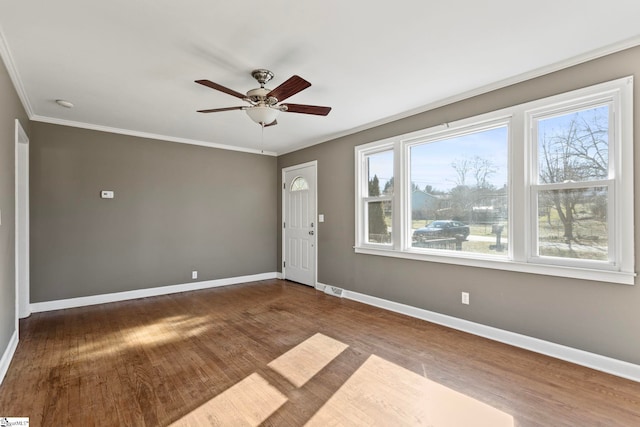 interior space with a ceiling fan, baseboards, crown molding, and wood finished floors