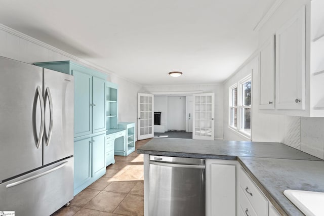 kitchen with a peninsula, stainless steel appliances, crown molding, white cabinetry, and open shelves