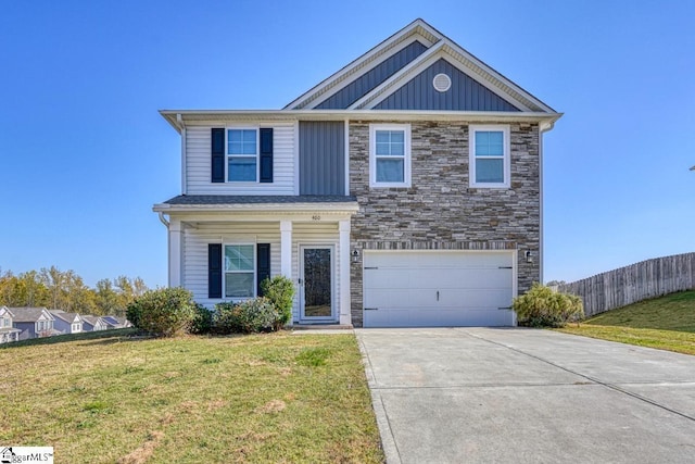 view of front of property featuring a garage, driveway, fence, and a front lawn