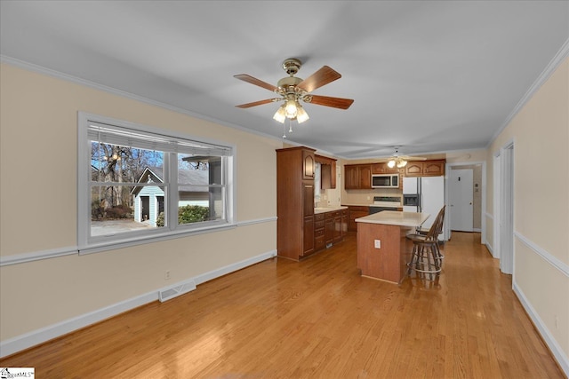 kitchen featuring ornamental molding, electric range, visible vents, and white refrigerator with ice dispenser