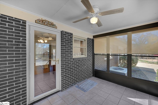 unfurnished sunroom featuring ceiling fan