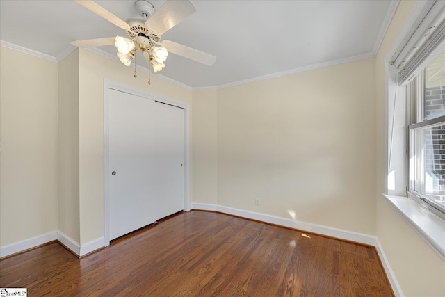 empty room featuring baseboards, wood finished floors, a ceiling fan, and crown molding