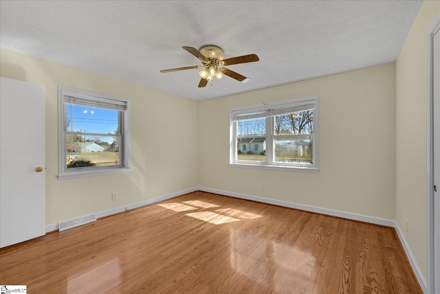 unfurnished bedroom with baseboards, visible vents, light wood-style flooring, and a textured ceiling