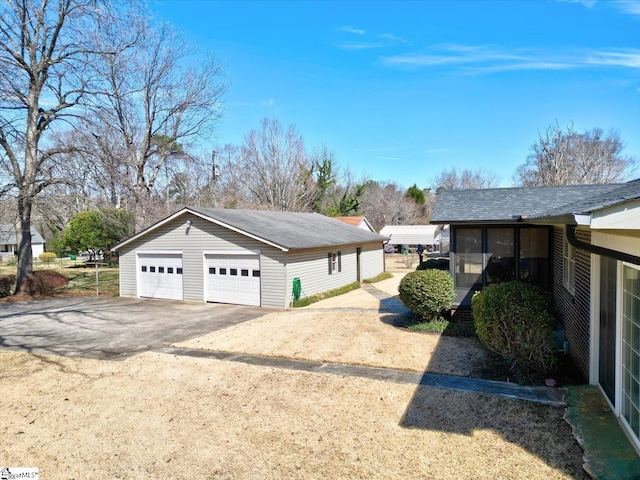 view of side of home featuring a detached garage and an outdoor structure