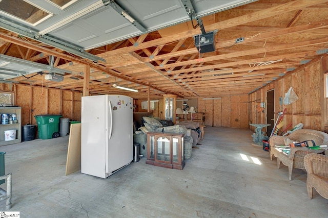 garage featuring freestanding refrigerator and a garage door opener