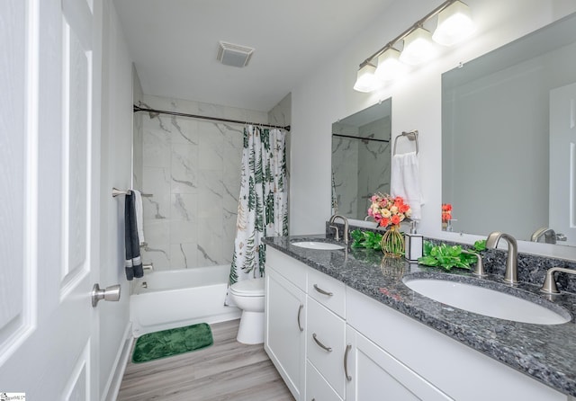 full bath featuring toilet, shower / bath combo with shower curtain, a sink, and visible vents