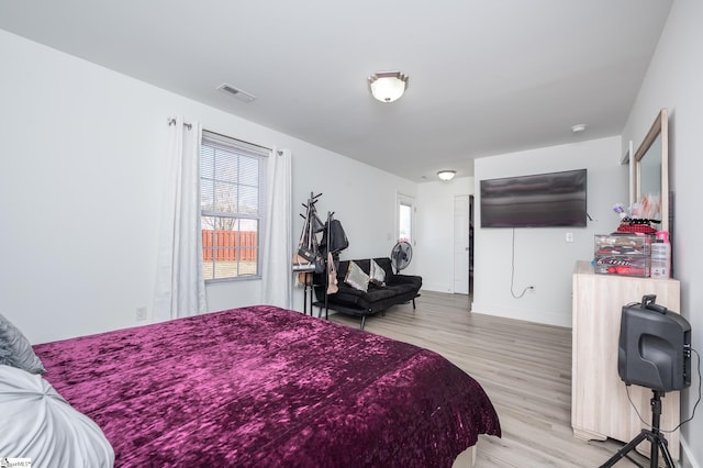 bedroom featuring light wood-type flooring, visible vents, and baseboards