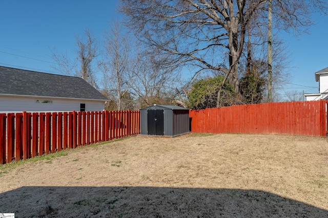 view of yard featuring an outbuilding, a fenced backyard, and a storage shed