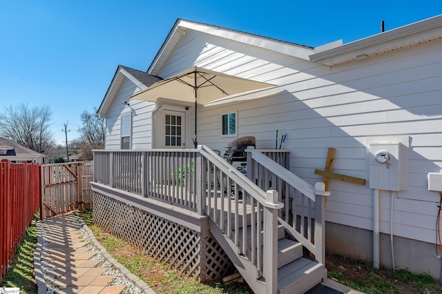 rear view of house with fence and a deck