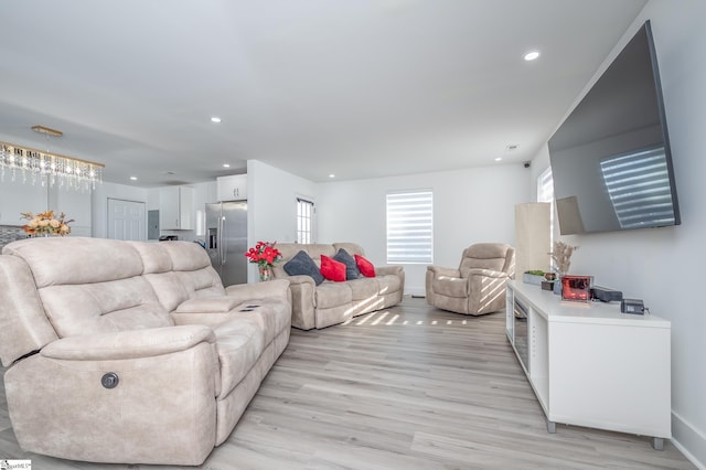 living room featuring light wood-style flooring, baseboards, and recessed lighting