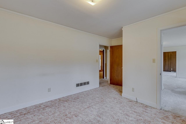 carpeted empty room with ornamental molding, visible vents, and baseboards