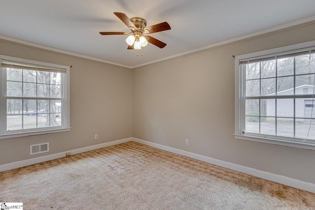 spare room featuring a healthy amount of sunlight, visible vents, and ornamental molding