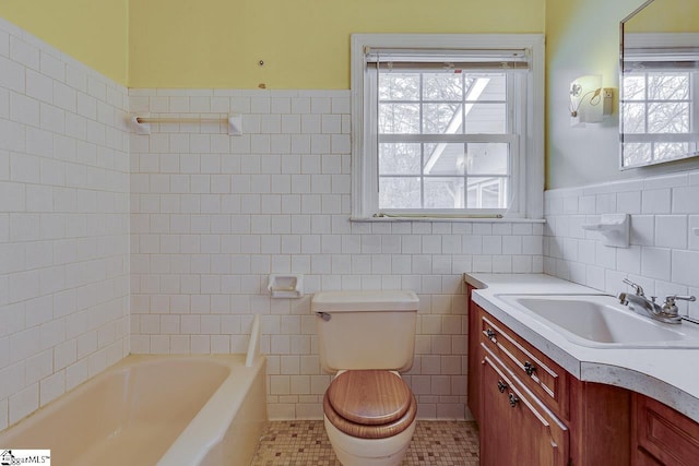 full bath with tile walls, toilet, wainscoting, vanity, and tile patterned floors