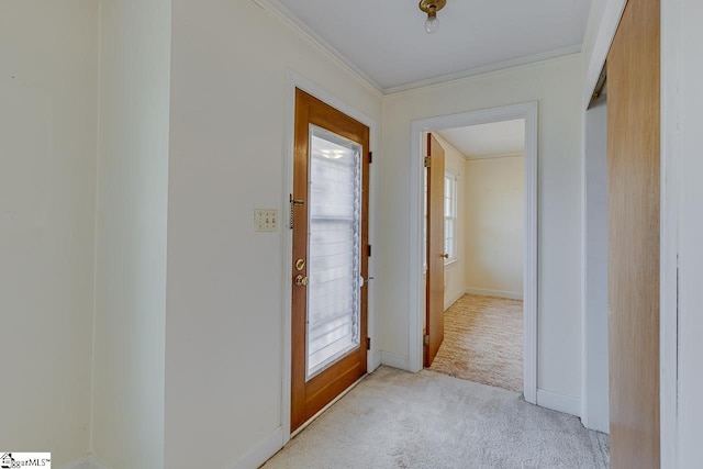 entryway with ornamental molding, light carpet, and baseboards