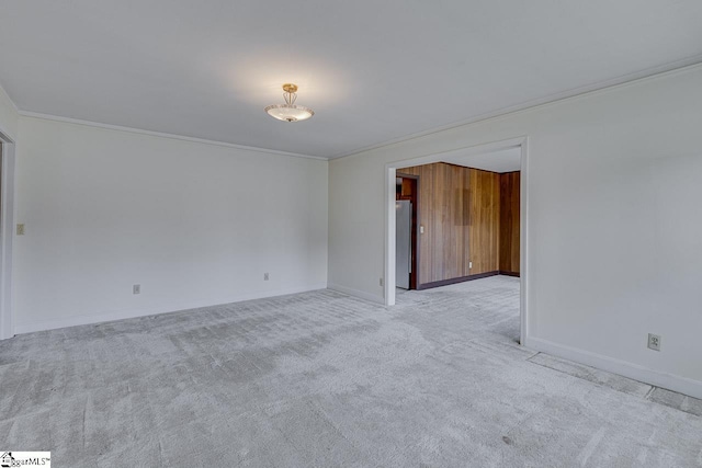 unfurnished room with ornamental molding, carpet flooring, and baseboards