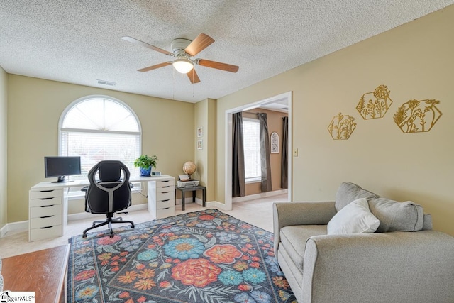 office area with light carpet, ceiling fan, a textured ceiling, and visible vents