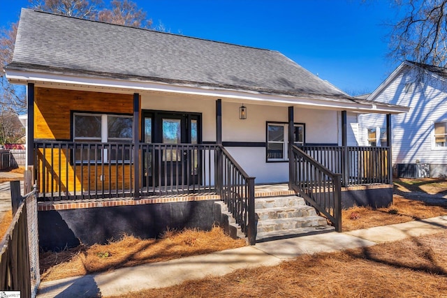 view of front of property with a porch, a shingled roof, and stucco siding