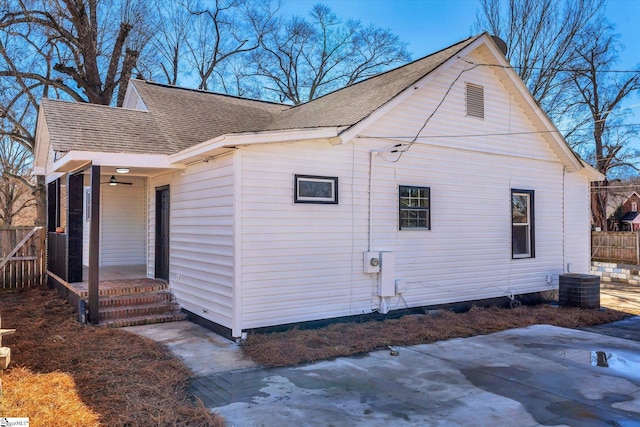 view of property exterior featuring a patio area, fence, central AC, and roof with shingles