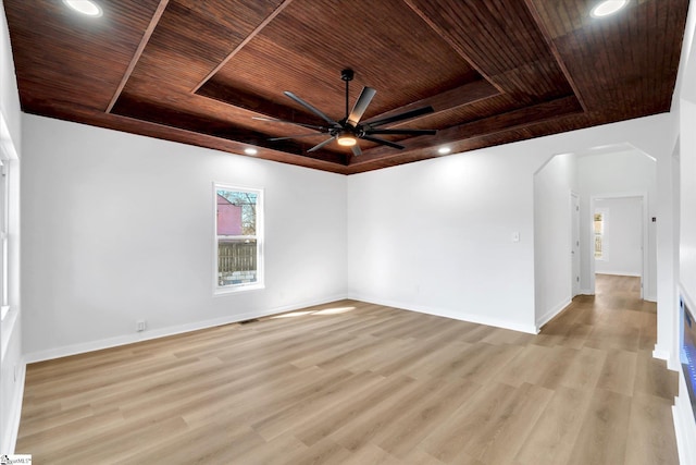 unfurnished room featuring wooden ceiling, baseboards, a raised ceiling, and light wood finished floors