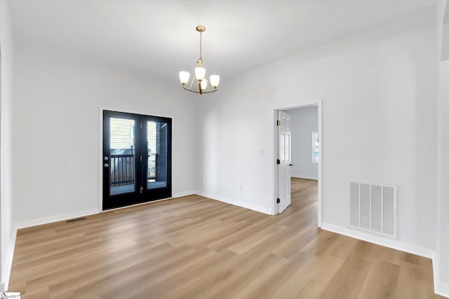 entrance foyer featuring baseboards, light wood-style flooring, visible vents, and an inviting chandelier