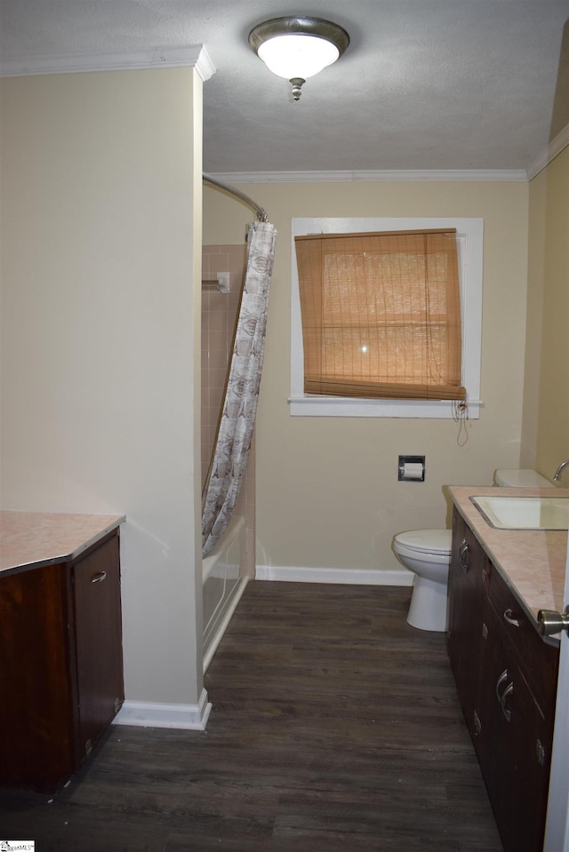 bathroom with toilet, wood finished floors, vanity, baseboards, and ornamental molding