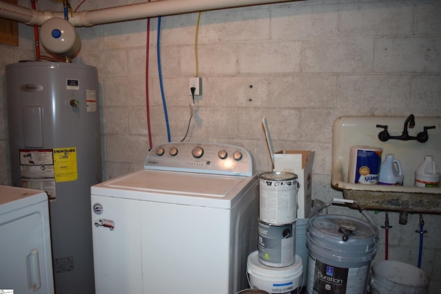 laundry area featuring water heater, laundry area, and washer / dryer