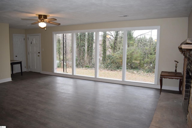 unfurnished living room featuring baseboards, visible vents, a wealth of natural light, and wood finished floors