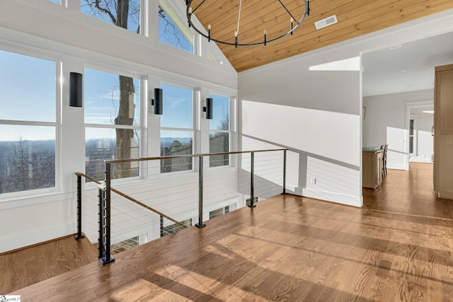 staircase with baseboards, visible vents, wooden ceiling, wood finished floors, and high vaulted ceiling