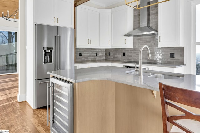 kitchen with wine cooler, high quality fridge, a sink, light wood-type flooring, and wall chimney exhaust hood