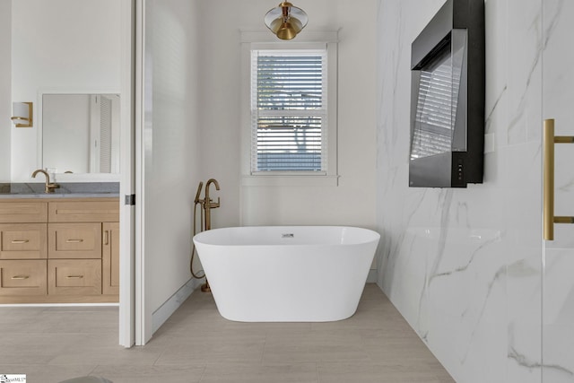 full bathroom with a freestanding tub and vanity