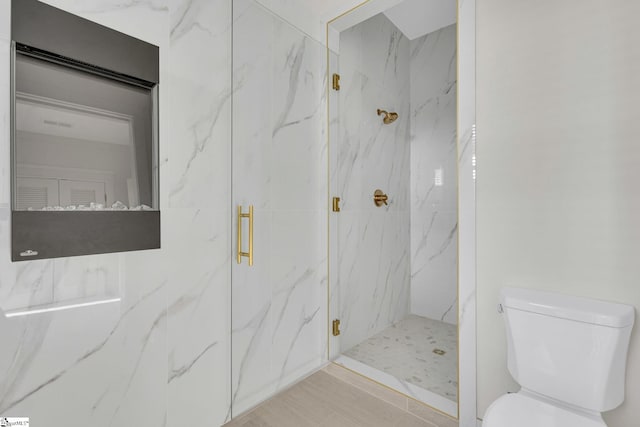 full bathroom with toilet and a marble finish shower