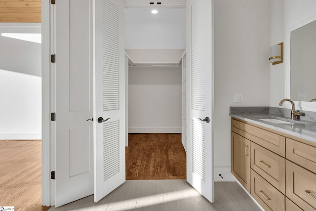 bathroom featuring wood finished floors, a closet, and vanity