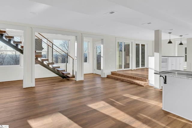 interior space featuring baseboards, stairs, visible vents, and dark wood-type flooring