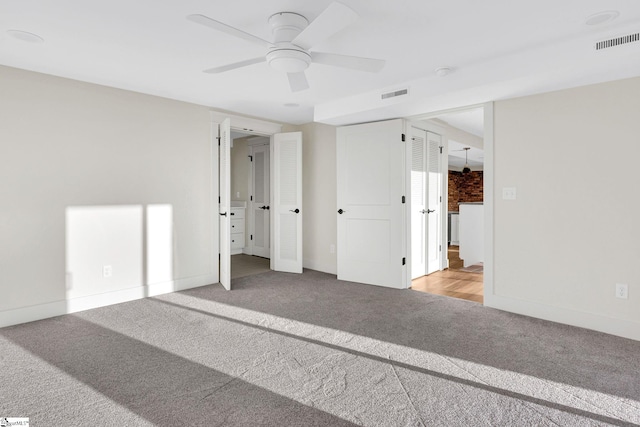 unfurnished bedroom with carpet, visible vents, and baseboards