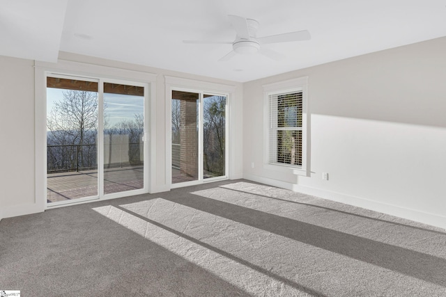 carpeted empty room with ceiling fan and baseboards