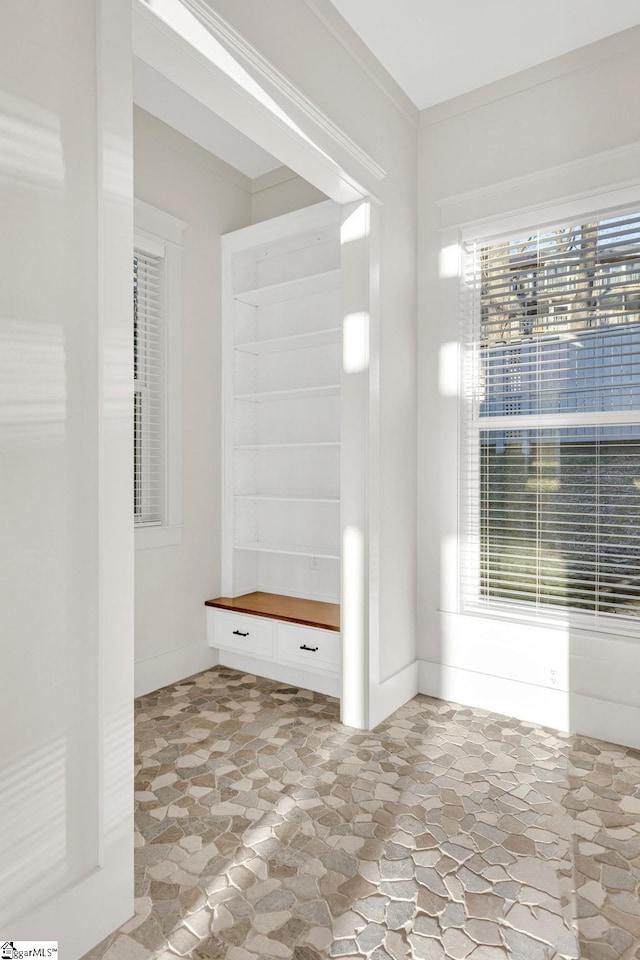 bathroom featuring stone finish flooring and ornamental molding