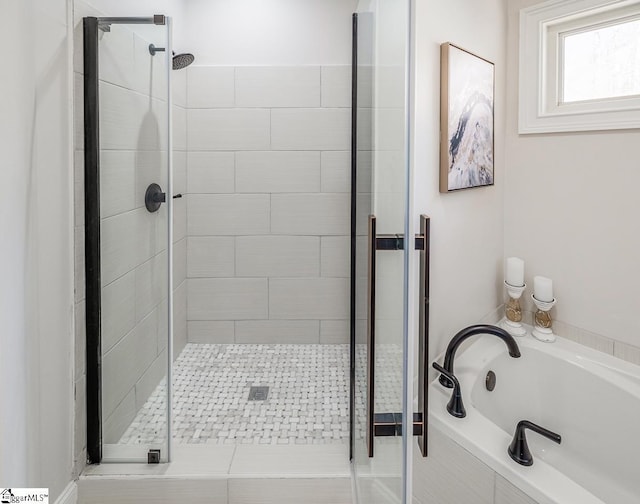 bathroom with a garden tub and a shower stall