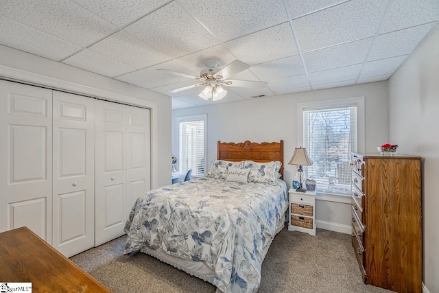 bedroom featuring carpet, visible vents, a drop ceiling, and a closet