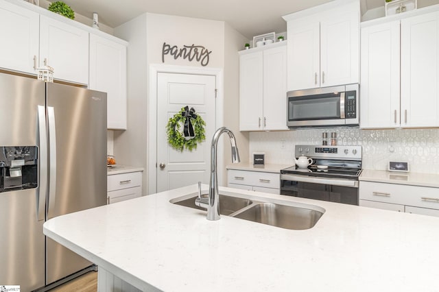 107 Tramore Ln, Fountain Inn, SC 29644 - kitchen featuring backsplash, white cabinets, a sink, and stainless steel appliances